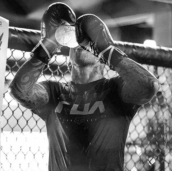 Ross Pearson covering up against the cage fence while drilling