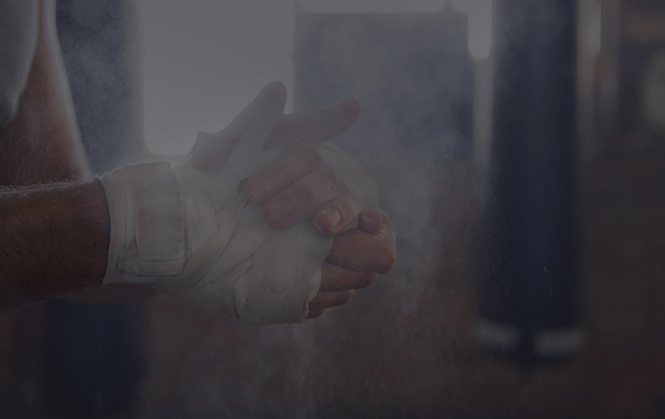 Hands being wrapped in front of a row of heavy bags